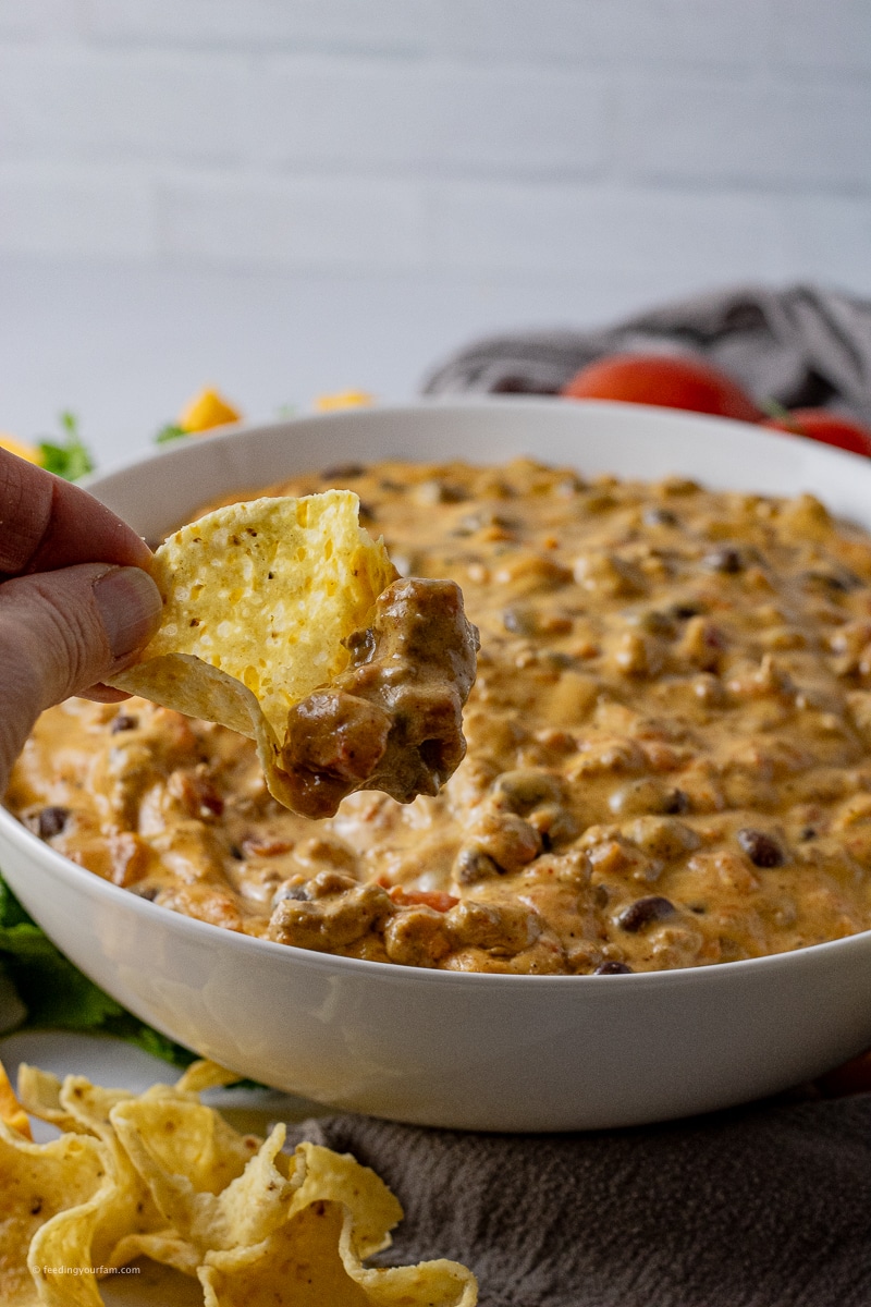 cup shaped chip scooping out some queso from a bowl
