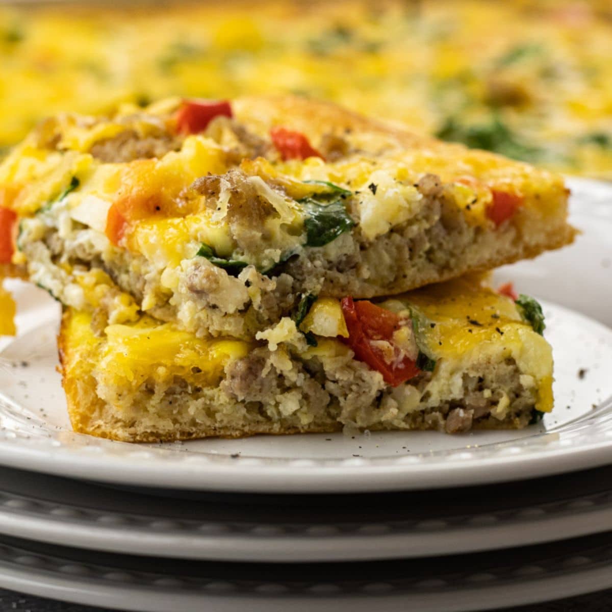 breakfast pizza made with sausage,cheese, eggs on a crescent roll crust