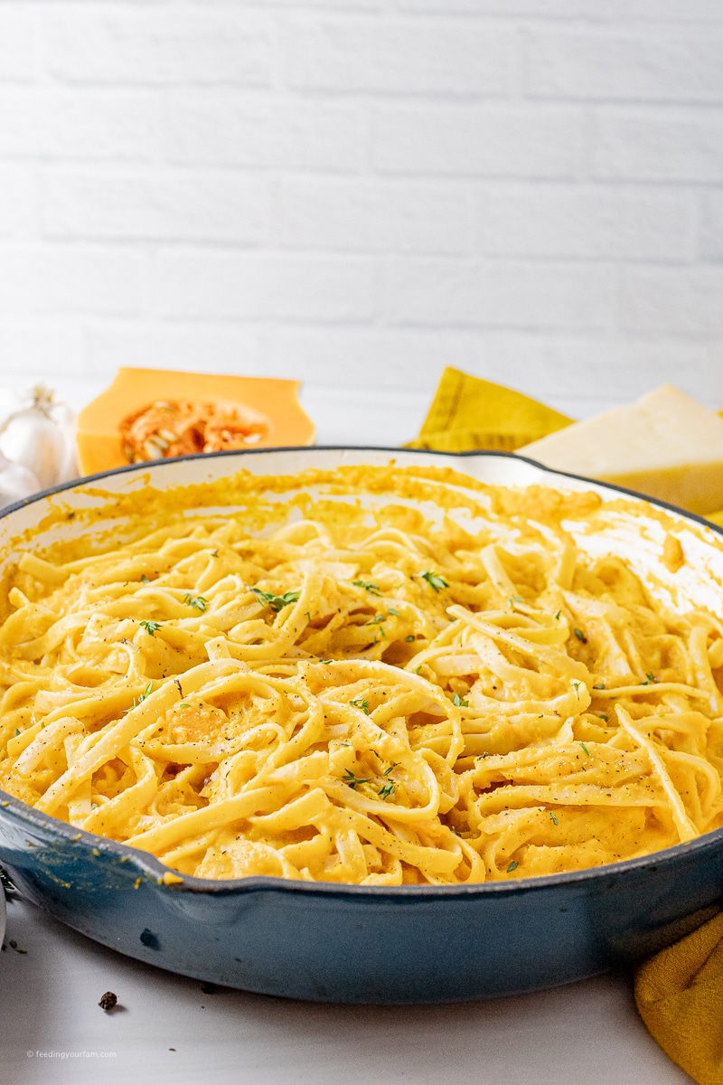 fettuccine noodles covered in a parmesan, butternut squash sauce in a large skillet