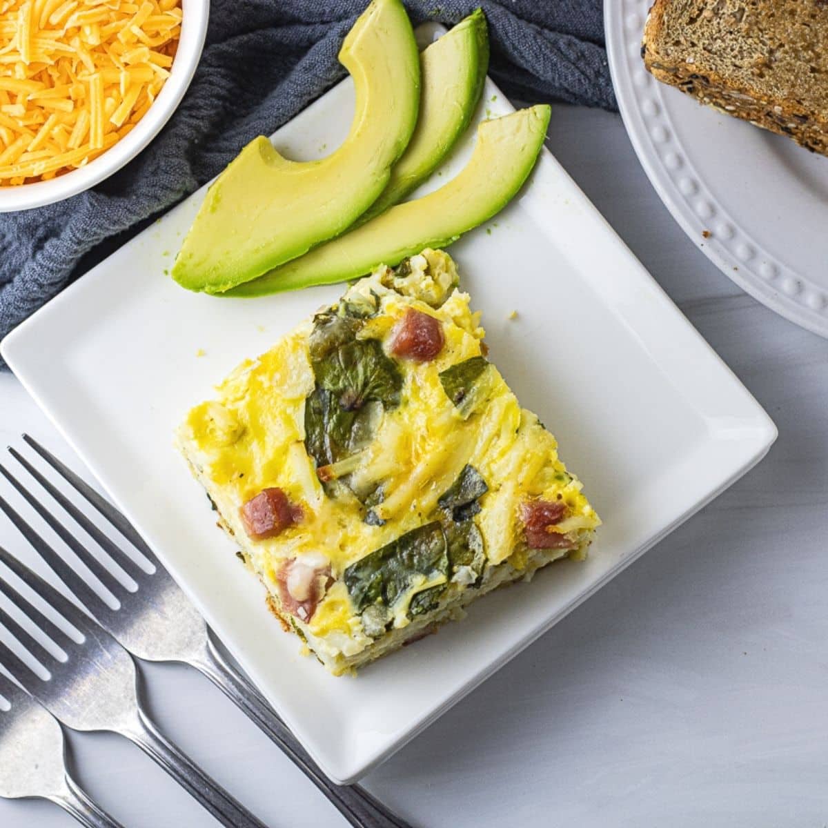 square piece of breakfast casserole on a white plate
