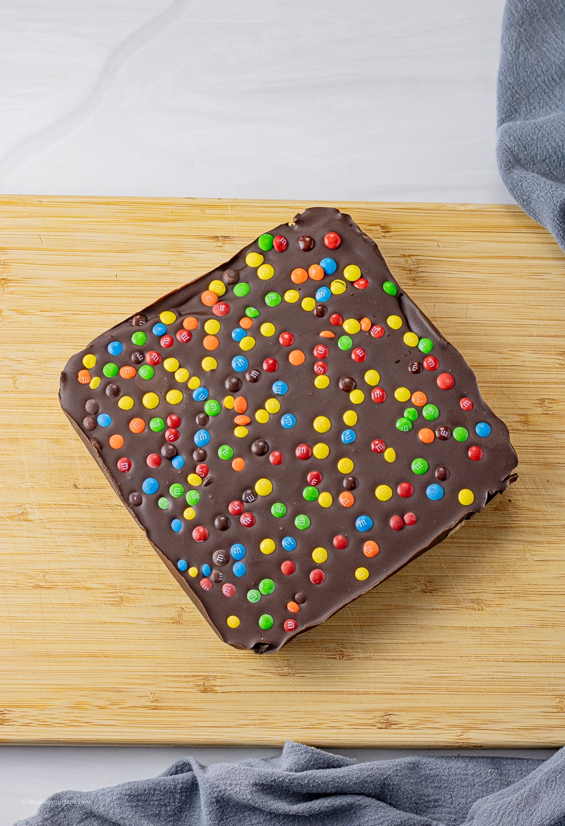 no bake cookie dough bars topped with chocolate and mini colored candies