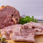sliced ham on a wooden cutting board