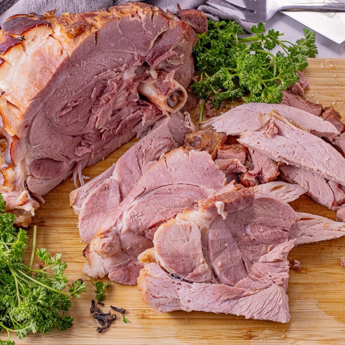 sliced ham on a wooden cutting board