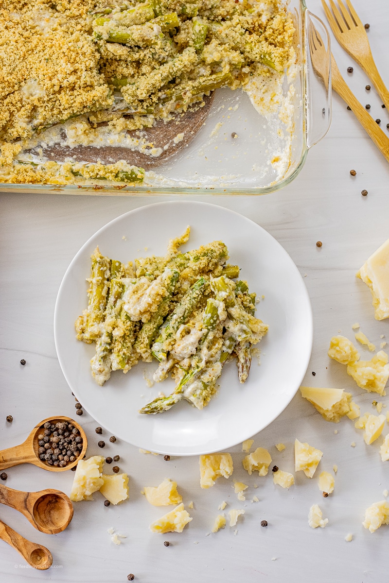sliced asparagus in a cream sauce on a white plate