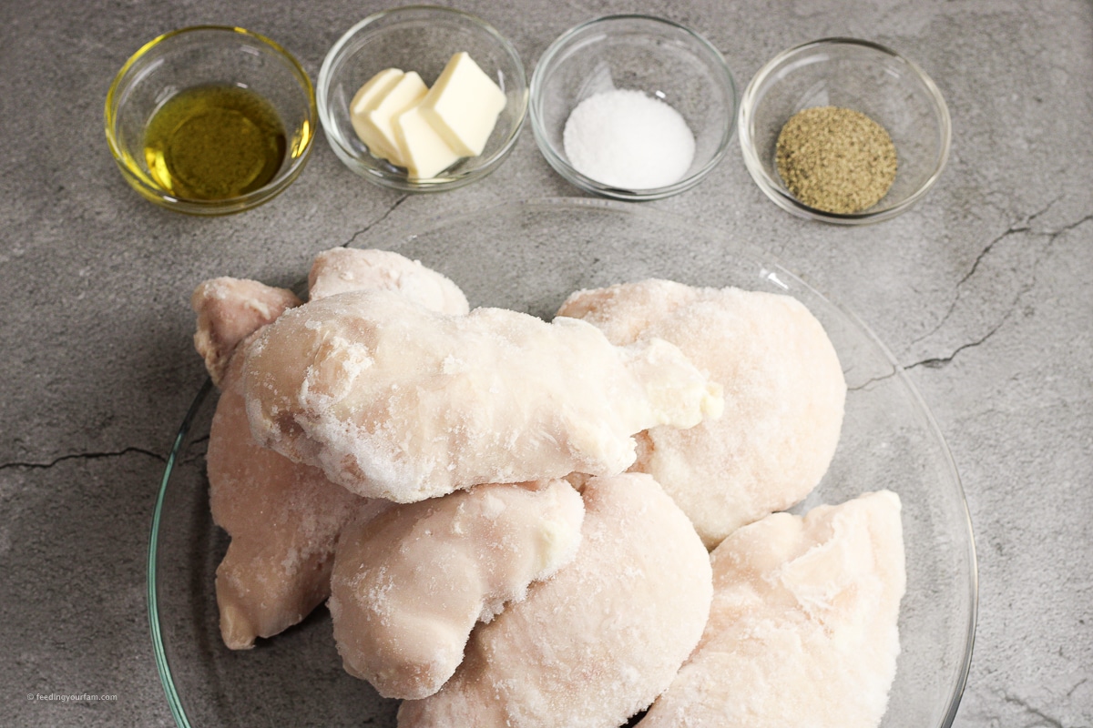 frozen chicken breasts preparing to be cooked in the oven with some oil, butter, salt and black pepper