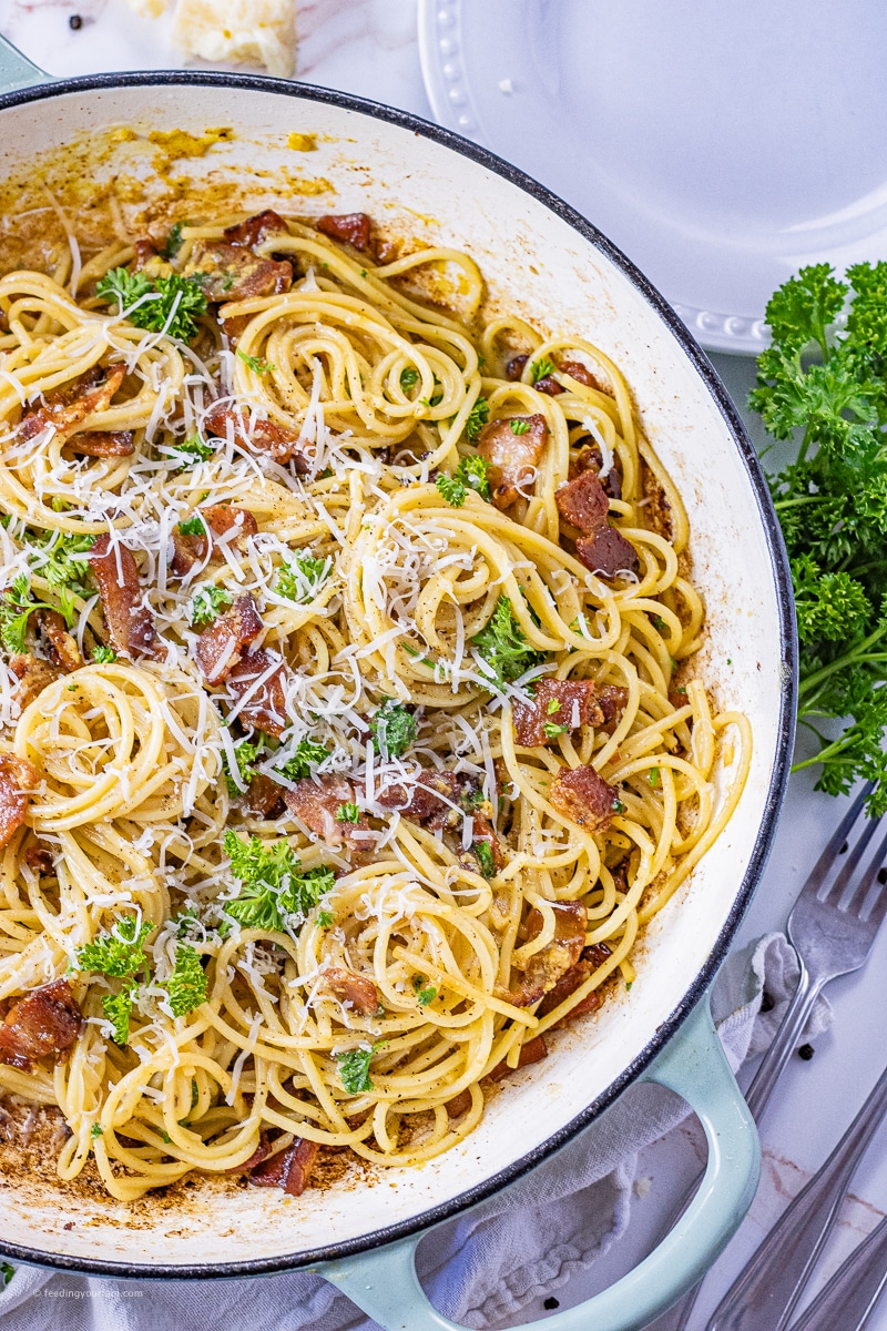 swirled piles of spaghetti mixed with bacon and parmesan cheese