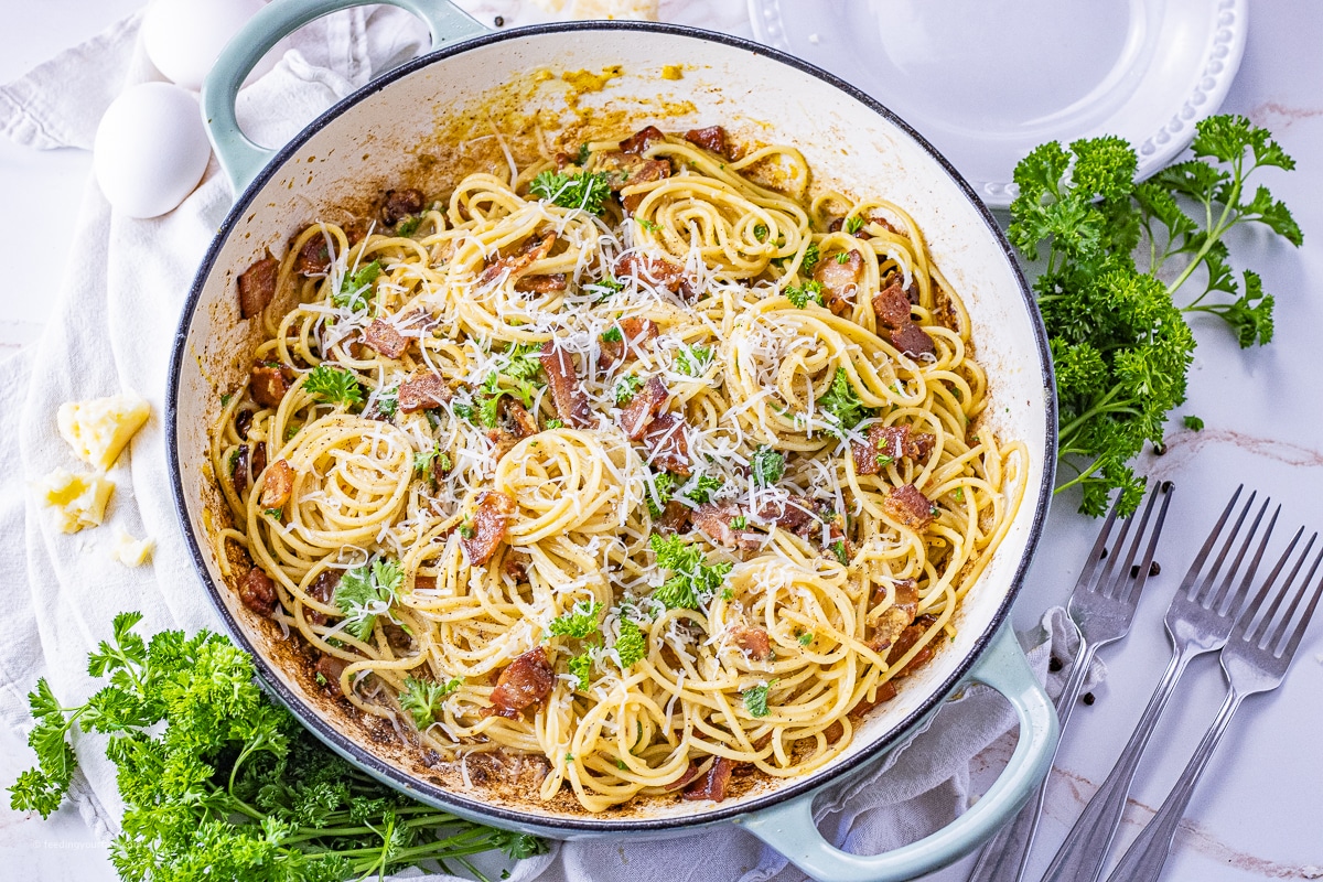 piles of spaghetti noodles mixed with bacon and parmesan cheese