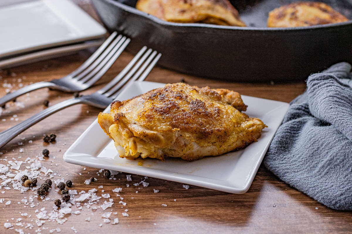 cooked chicken thigh on a small square plate