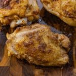 oven baked chicken thighs on a wooden cutting board