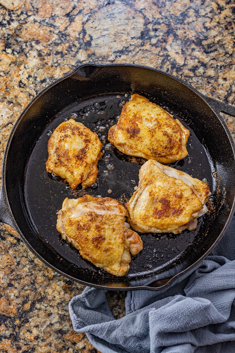 4 chicken thighs in a black cast iron pan