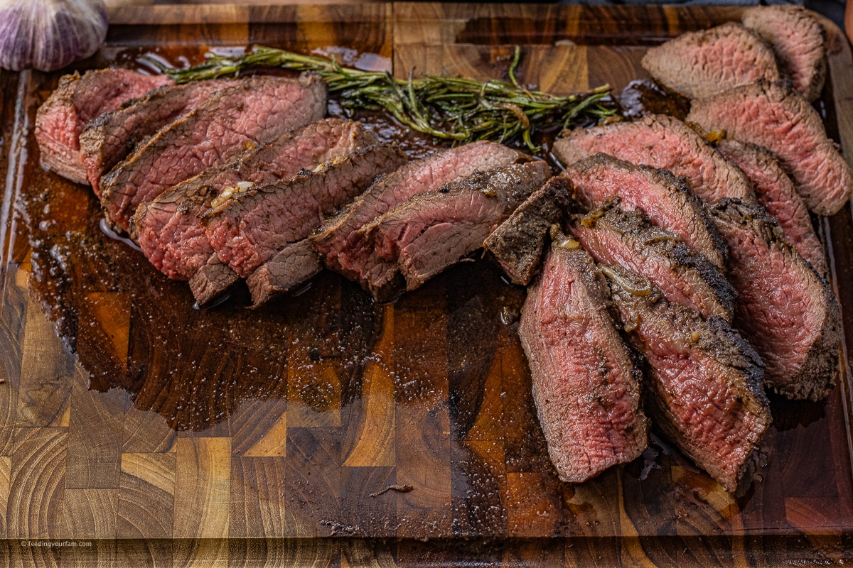 sliced tri tip on a wooden cutting board