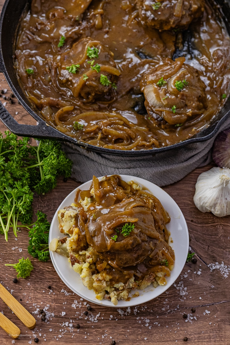 hamburger steaks topped with onion gravy over mashed potatoes