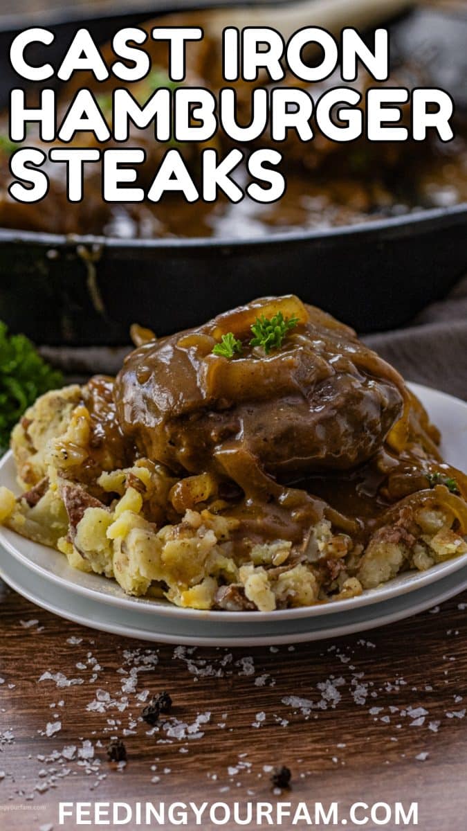Hamburger steak with onion gravy over mashed potatoes with the words cast iron hamburger steaks written on it