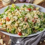 caesar salad with chicken and bowtie pasta on a serving platter