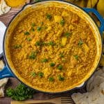 red lentil curry recipe made with chicken in coconut milk all cooked in a large enameled cast iron pan
