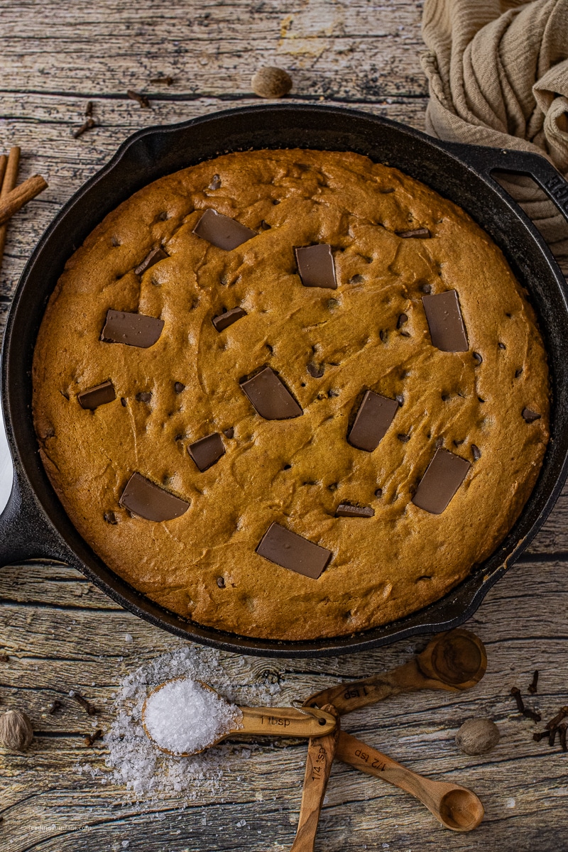 cast iron skillet with a pumpkin chocolate chip cookie baked in it