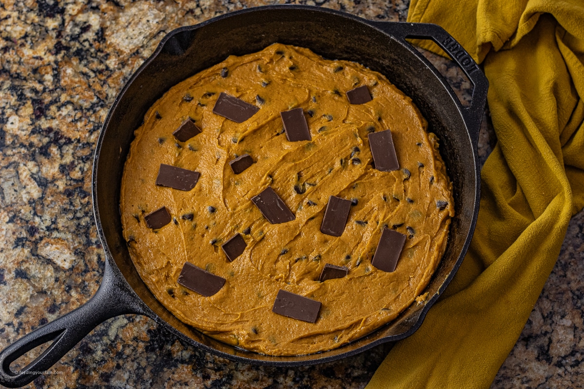 uncooked pumpkin chocolate cookie in a cast iron skillet