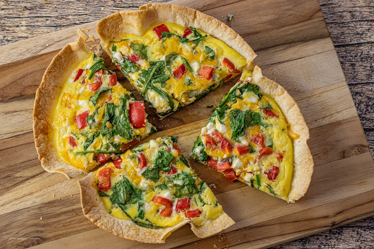 tortilla egg bake sliced into four pieces on a wooden cutting board