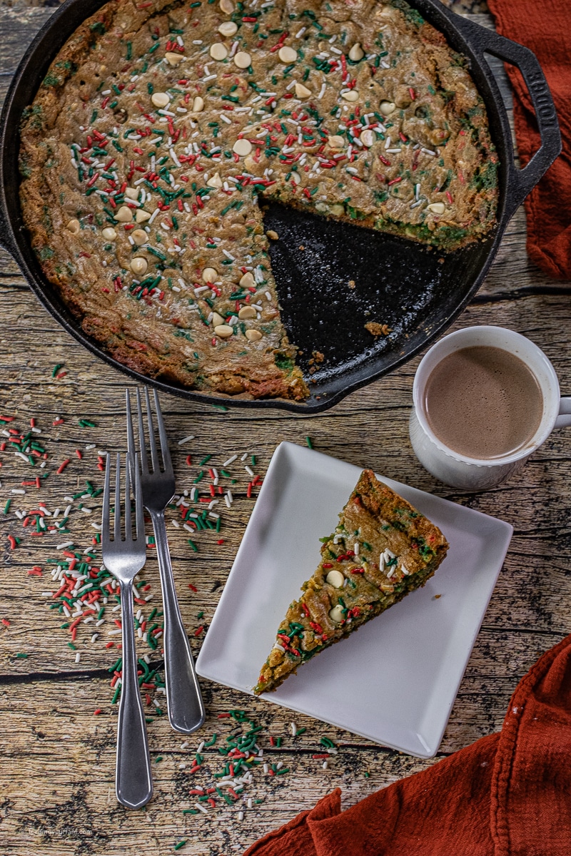 giant sugar cookie with Christmas sprinkles baked in a cast iron skillet