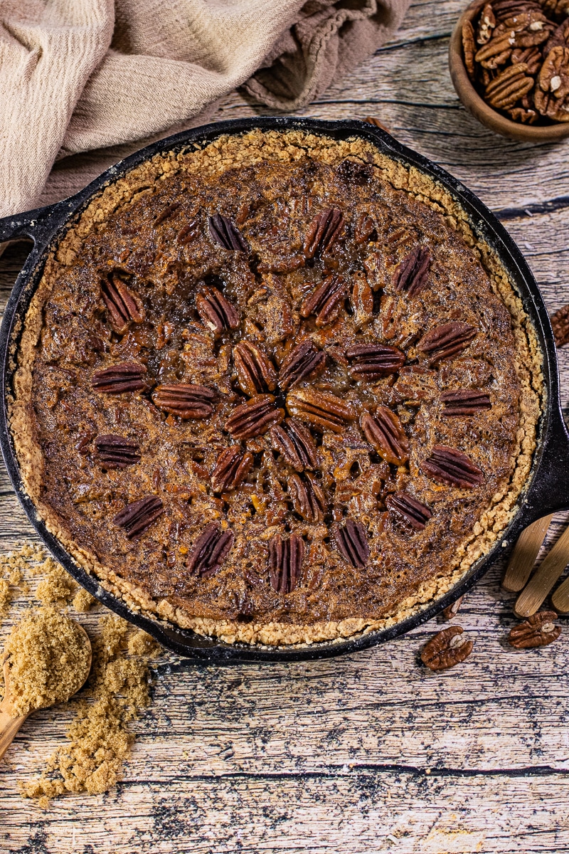 pecan pie baked in a cast iron skillet with pecans on top