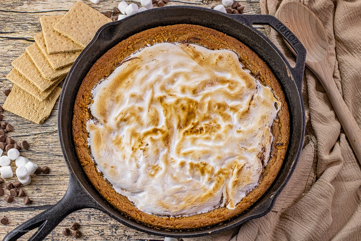 Toasted marshmallow topping turning golden under the broiler in a cast iron skillet
