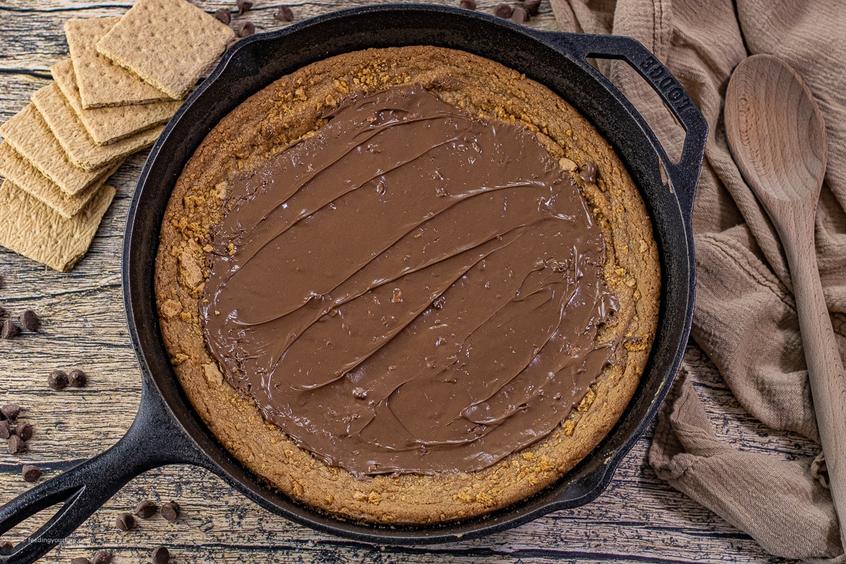 Freshly baked skillet cookie with melted chocolate spread across the top