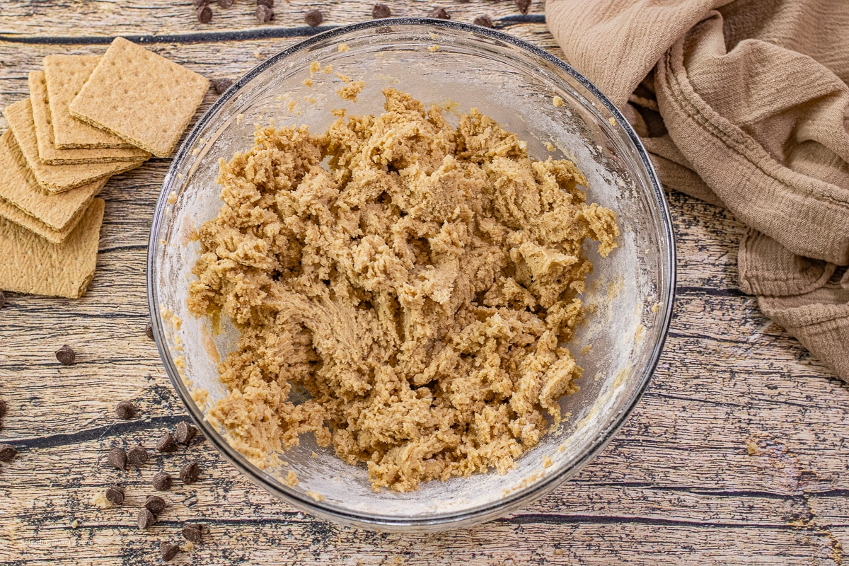Graham cracker cookie dough being mixed in a bowl for skillet s’mores cookie recipe