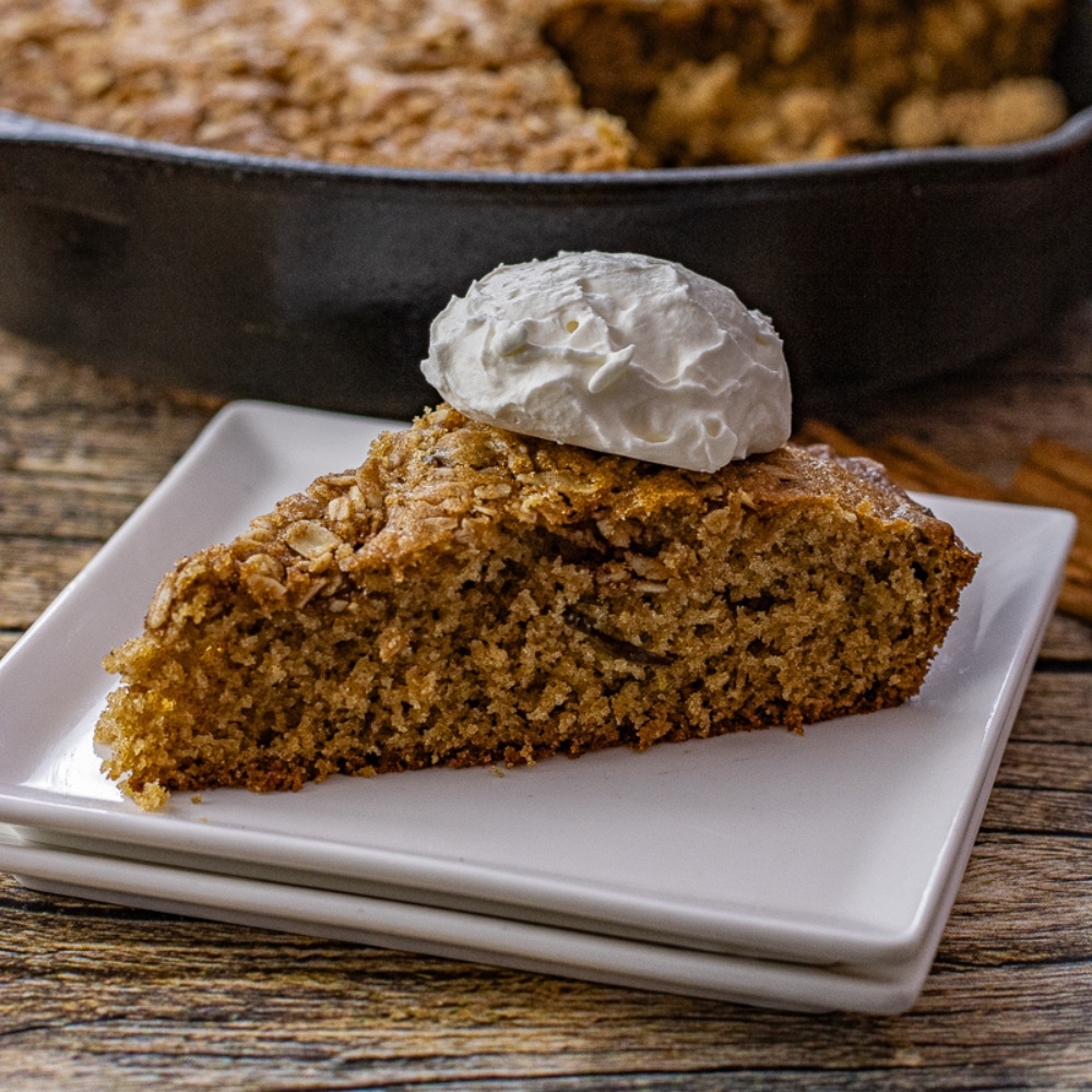 slice of apple cinnamon cake that has been baked in a cast iron skillet