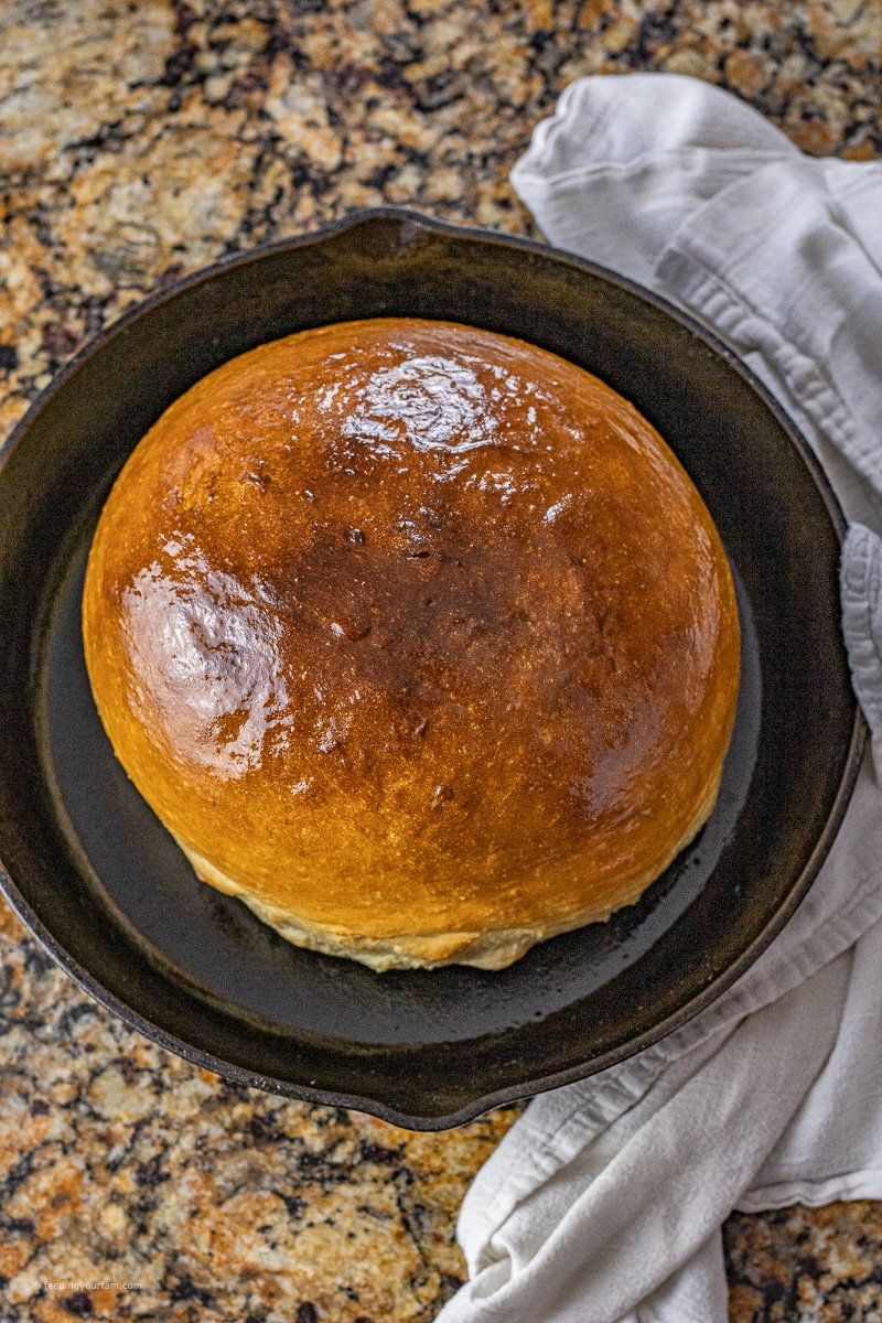 large round loaf of white bread in a cast iron skillet