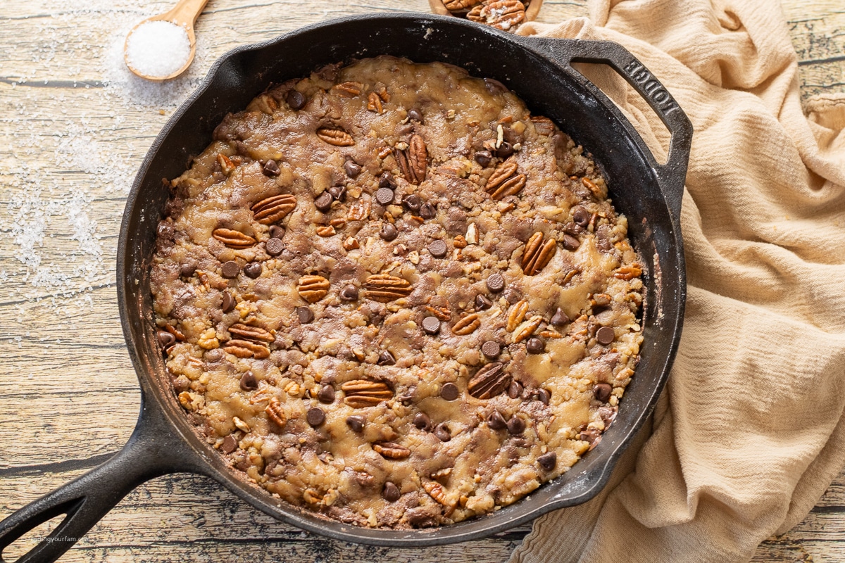 uncooked chocolate chip pecan cookie dough in a cast iron skillet