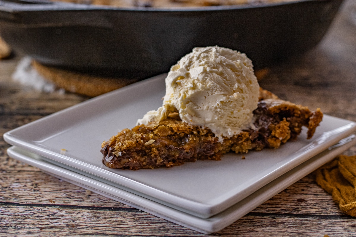 slice of salted caramel skillet cookie topped with vanilla ice cream