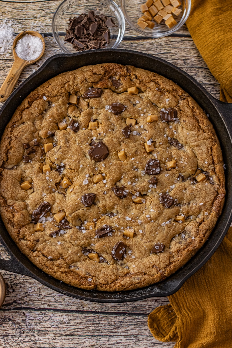 chocolate chip cookie with caramel and chocolate chunks in a cast iron skillet