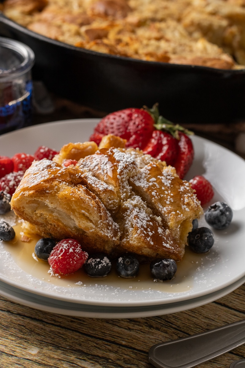 french toast casserole on a white plate with berries