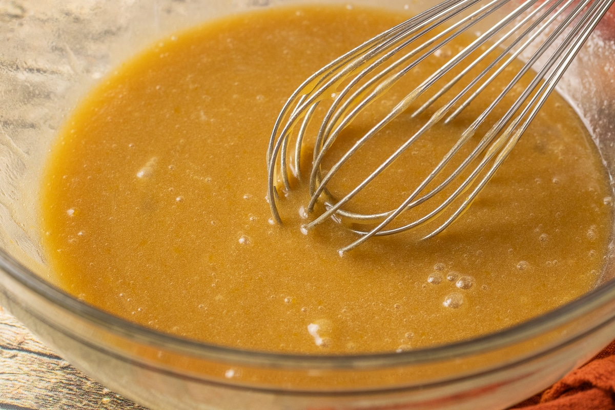 butter, brown sugar, eggs, and vanilla mixed in a glass mixing bowl
