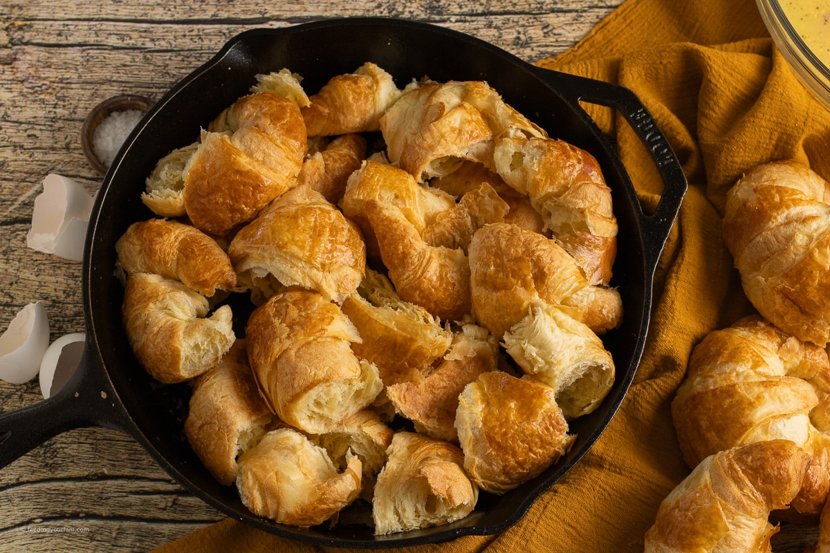 torn up croissants in a cast iron skillet