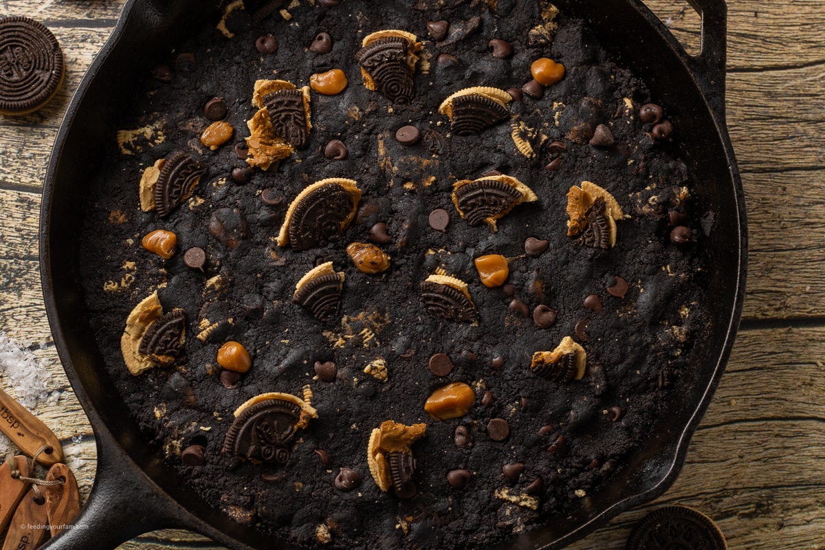 black cookie dough topped with crushed Oreos, caramel pieces and chocolate chips