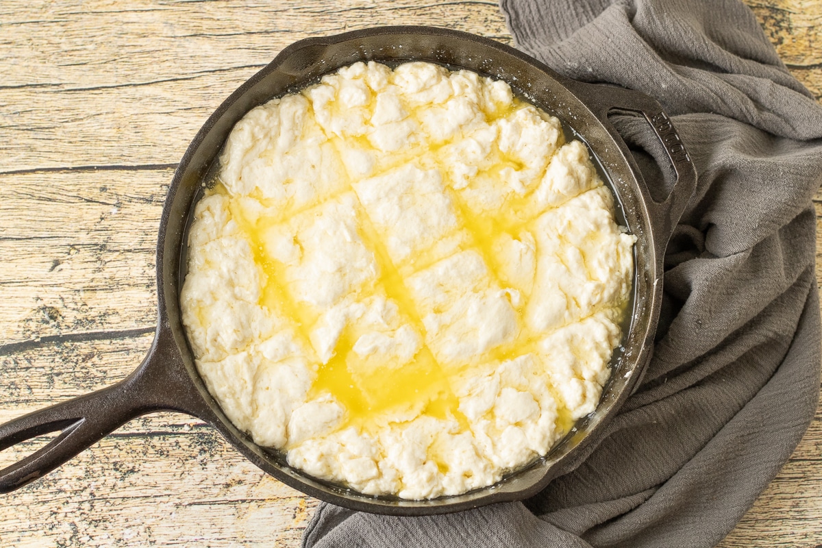 uncooked butter swim biscuit dough in butter in a cast iron skillet