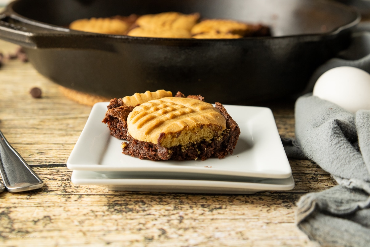 brownie topped with a peanut butter cookie cooked in a cast iron skillet