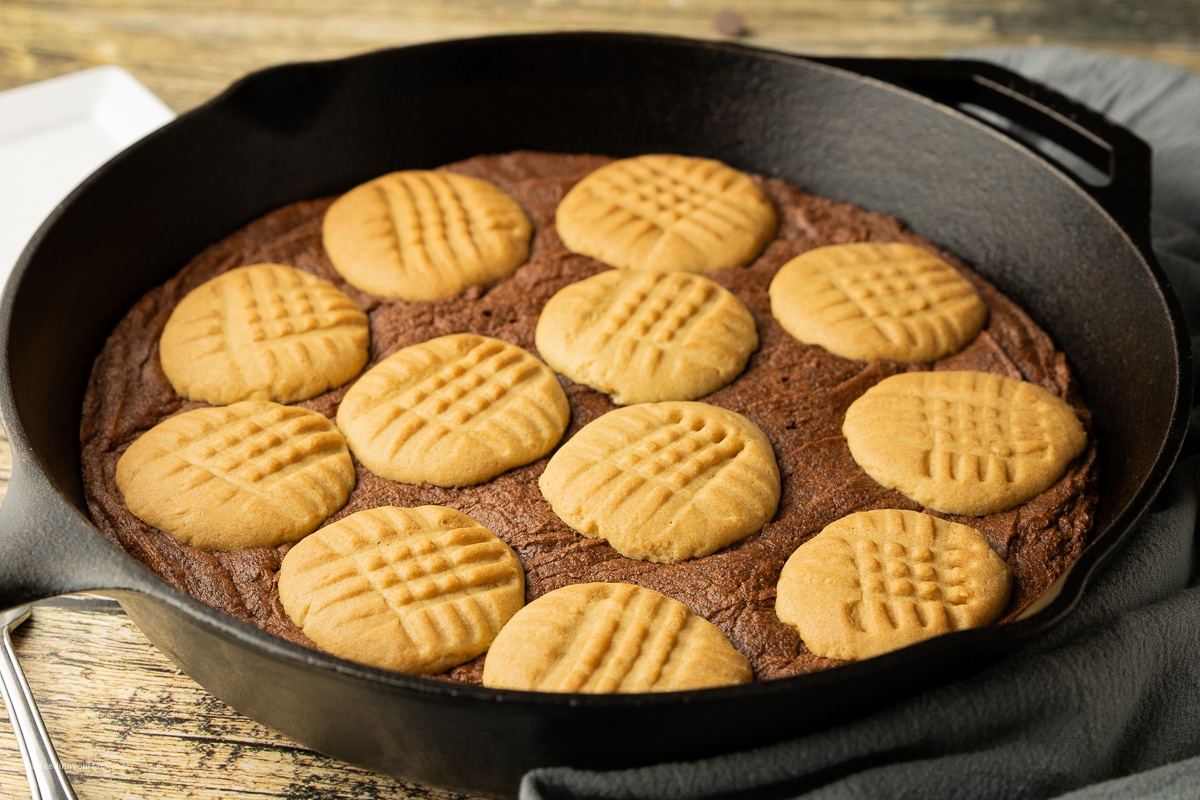 brownie topped with peanut butter cookies in a cast iron skillet. Cast iron skillet cookie recipe