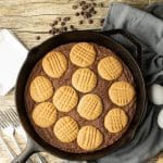 brownie topped with peanut butter cookies in a cast iron skillet