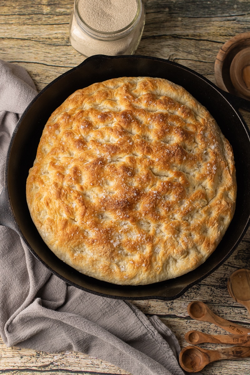 overhead view of golden brown focaccia baked in a cast iron skillet