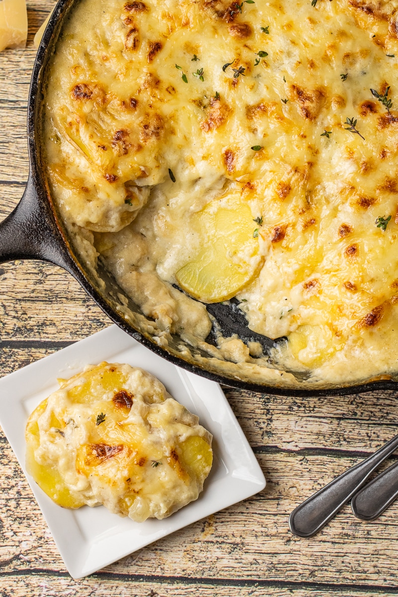 Hot, bubbling, cheesy Scalloped Potatoes are tender golden potatoes baked in a creamy Swiss cheese sauce right in a cast iron skillet. Cast Iron recipe.