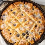 butter swim biscuits with blueberry baked in a cast iron skillet