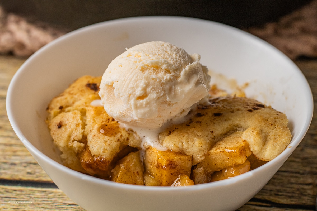 apple cobbler with caramelized baked apples topped with a scoop of vanilla ice cream