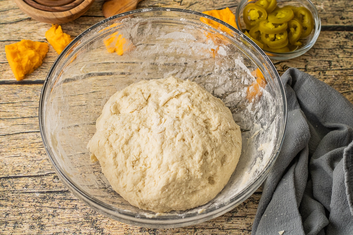 bread dough for jalapeno cheese bread in a glass bowl