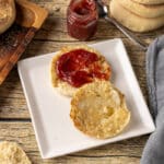 English muffins are small round yeast breads traditionally cooked on a griddle rather than baked. Their slow cooking method creates a chewy crust and airy interior filled with pockets that hold melted butter and jam.